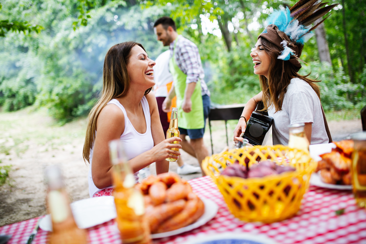 Group of happy friends having a barbecue party in nature