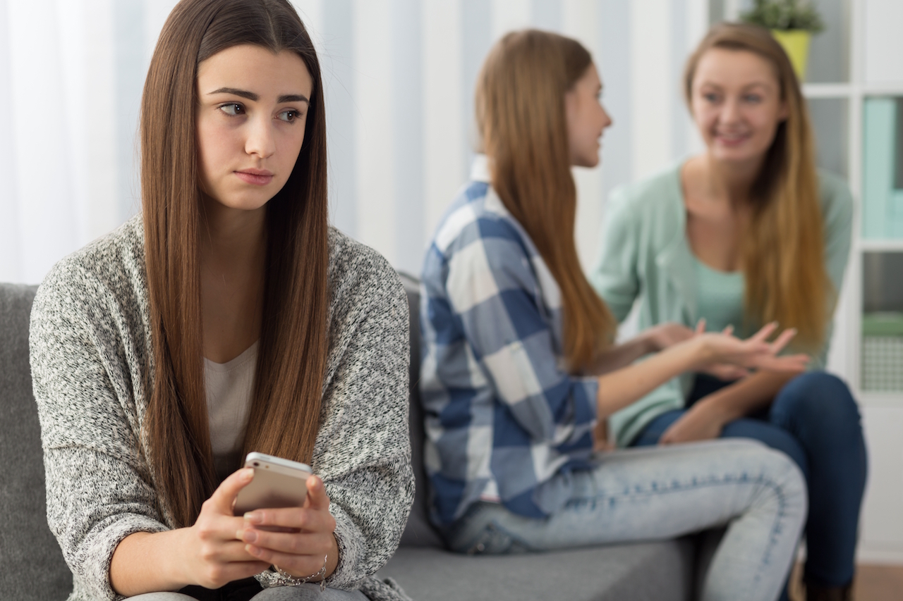 Sad girl holding her phone